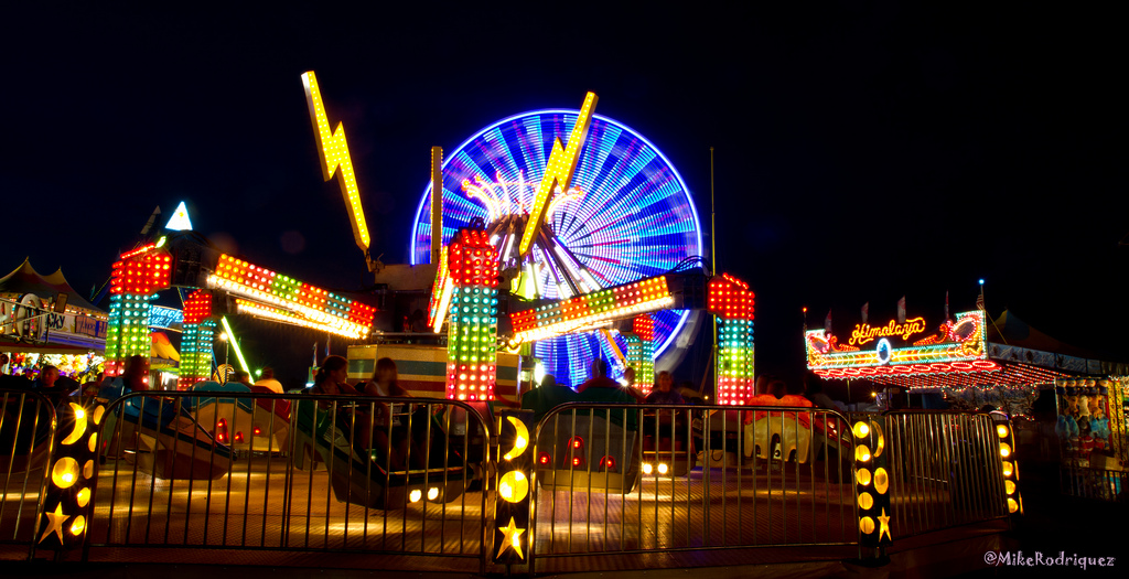Photo of brightly lit rides at a fairground