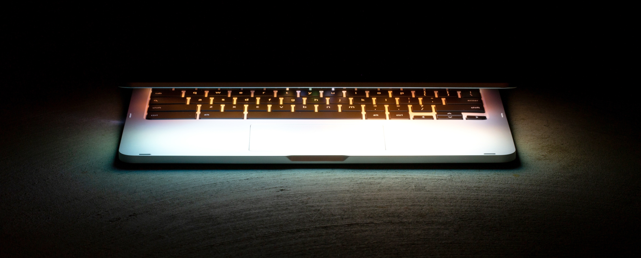 photo of a glowing half-open laptop