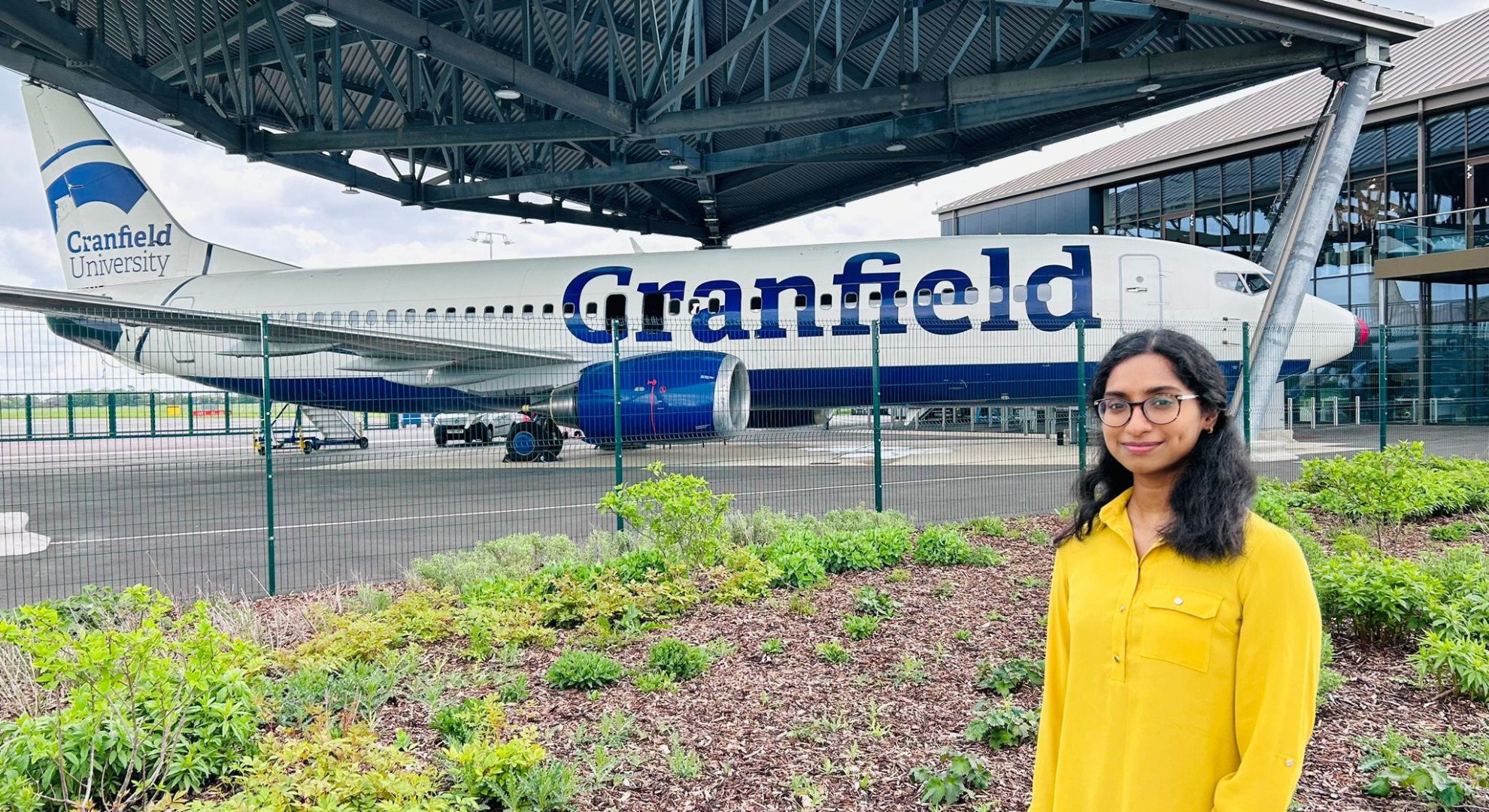 Jesintha standing outside the Cranfield Boeing 737-800 aircraft.
